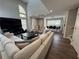 A bright living room features soaring windows, a comfortable L-shaped couch and a large TV at 3050 Camden Way, Alpharetta, GA 30005