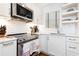 Modern kitchen with stainless steel appliances, white cabinets, tile backsplash, and open shelving at 35 Sheridan Ne Dr # 7, Atlanta, GA 30305