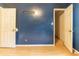 Bedroom with blue walls and wooden floors featuring two doors and an open closet at 4507 Laurie Ln, Powder Springs, GA 30127
