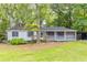 Charming single-story home with a screened front porch and a lush, tree-filled yard and dual carports at 4507 Laurie Ln, Powder Springs, GA 30127