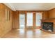 Cozy living room with wood-paneled walls, multiple windows, fireplace, and hardwood floors at 4507 Laurie Ln, Powder Springs, GA 30127