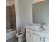 Bright bathroom featuring a tub with stone tile surround and a white vanity with a large mirror at 1616 Avery Way, Tucker, GA 30084