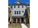 New construction townhome with a covered front porch, wood columns, and board and batten siding at 1616 Avery Way, Tucker, GA 30084