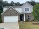 Charming two-story home featuring brick and siding exterior, a well-manicured lawn, and a two car garage at 2349 Argento Cir, Dacula, GA 30019
