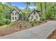 Charming painted brick home with an extended driveway surrounded by lush landscaping and mature trees at 2680 Spalding Dr, Atlanta, GA 30350