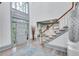 Sunlit foyer with gray-painted trim, grand staircase, high ceilings, and beautiful hardwood flooring at 2680 Spalding Dr, Atlanta, GA 30350
