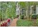 Home featuring a painted brick front entrance with manicured bushes, trees, and a brick walkway at 2680 Spalding Dr, Atlanta, GA 30350
