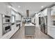 Modern kitchen boasts stainless steel appliances, white cabinetry, and an island with cooktop at 2680 Spalding Dr, Atlanta, GA 30350