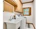 Laundry room equipped with utility sink and washer/dryer, plus outdoor view and ample storage at 2680 Spalding Dr, Atlanta, GA 30350