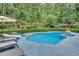 Serene backyard oasis featuring a sparkling pool, sunbathing area, and lush greenery for ultimate relaxation and privacy at 2680 Spalding Dr, Atlanta, GA 30350