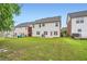 Large backyard featuring multi-Gathering homes, a lush yard, and a small patio at 909 Pine Cove Dr, Lilburn, GA 30047
