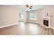 Cozy living room featuring a fireplace, hardwood floors, and views of the dining area at 909 Pine Cove Dr, Lilburn, GA 30047