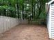 Home's backyard features pine straw ground cover and a wood fence at 1903 Brittania Cir, Woodstock, GA 30188