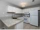 Bright kitchen featuring white appliances, granite countertops, and modern lighting at 1903 Brittania Cir, Woodstock, GA 30188