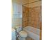 Cozy bathroom features a toilet, bathtub, and tiled wall. It also has overhead cabinets at 207 Brownlee Sw Rd, Atlanta, GA 30331