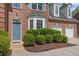 Charming front entrance with a blue door, surrounded by lush landscaping and a brick facade at 4535 Howell Farms Nw Rd, Acworth, GA 30101