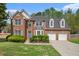 Charming brick home with a well-manicured lawn, blue door, and two-car garage at 4535 Howell Farms Nw Rd, Acworth, GA 30101
