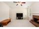 Cozy living room with plush carpet, ceiling fan, brick fireplace, and large TV at 4535 Howell Farms Nw Rd, Acworth, GA 30101