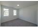 Bright bedroom with neutral carpet, two large windows, and backyard views at 2260 Siskin Square Rd # 90, Duluth, GA 30096