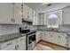 Updated kitchen featuring granite counters, white cabinets, stainless steel appliances, and subway tile backsplash at 4278 Trotters Ln, Auburn, GA 30011
