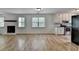 Spacious living room featuring a stone fireplace, large windows, and modern flooring at 4278 Trotters Ln, Auburn, GA 30011