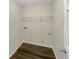 A compact laundry room with wood-look vinyl flooring and shelving for storage at 6260 Selborn Sw Dr, Atlanta, GA 30331