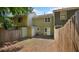 Backyard with a wood fence and the exterior of the multi-colored townhome at 6964 Oakhill Cir, Austell, GA 30168