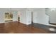 Open-concept living room with hardwood floors, white walls, and access to kitchen and backyard at 6964 Oakhill Cir, Austell, GA 30168