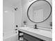 Modern bathroom with sleek vanity, round mirror, and a bathtub-shower combo with updated fixtures at 783 Lost Creek Cir, Stone Mountain, GA 30088