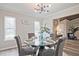Chic dining room with modern chandelier, round glass table set for four, and natural light from the windows at 783 Lost Creek Cir, Stone Mountain, GA 30088