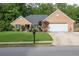 Charming brick home featuring a manicured lawn, mature trees, and a two-car garage at 1520 Great Oaks Dr, Lawrenceville, GA 30045