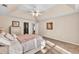 View of main bedroom, highlighting the tray ceiling, ceiling fan, and cozy textures of the bed and carpet at 1520 Great Oaks Dr, Lawrenceville, GA 30045