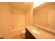 Bright bathroom featuring a granite countertop, sink, and a shower-tub combination at 1560 Iris Walk, Jonesboro, GA 30238