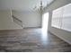 Open dining area with wood-like floors, a chandelier, and staircase access to the upper level at 1560 Iris Walk, Jonesboro, GA 30238