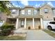 Charming townhome featuring a brick and gray facade, a covered porch, and a well-maintained lawn at 1560 Iris Walk, Jonesboro, GA 30238