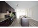Modern kitchen with dark cabinets, granite counters, and a central island flowing into the dining area at 1560 Iris Walk, Jonesboro, GA 30238
