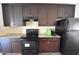 Well-equipped kitchen with dark cabinetry, granite countertops, and black appliances at 1560 Iris Walk, Jonesboro, GA 30238