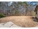 Expansive backyard features dry, dormant grass and mature trees, providing ample space at 1791 Lake George Dr, Lithia Springs, GA 30122