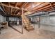 Unfinished basement features wooden support beams and an open staircase at 1791 Lake George Dr, Lithia Springs, GA 30122