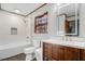 Bright bathroom offers a modern vanity, tub-shower with stylish white tile and bronze accents at 1791 Lake George Dr, Lithia Springs, GA 30122