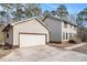 View of the home's exterior, featuring a detached garage with a large white door and light colored siding at 1791 Lake George Dr, Lithia Springs, GA 30122