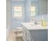 A bathroom featuring a white vanity, a toilet, a mirror and blue walls at 3146 Alston Dr, Decatur, GA 30032