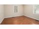 A bright bedroom features wood-look flooring and neutral walls and two windows at 3146 Alston Dr, Decatur, GA 30032