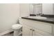Bathroom featuring a toilet, white vanity with a dark countertop and sink with framed mirror at 7004 Pat Mell Se Pl, Smyrna, GA 30080