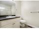 Bathroom featuring a toilet, white vanity with a dark countertop and sink with framed mirror at 7004 Pat Mell Se Pl, Smyrna, GA 30080
