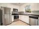 Modern kitchen with stainless steel appliances, light countertops, and classic white cabinetry at 7004 Pat Mell Se Pl, Smyrna, GA 30080