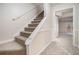 Carpeted staircase with white trim leading to the lower level of the home at 7004 Pat Mell Se Pl, Smyrna, GA 30080