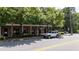 Exterior of the building featuring brick and stone facade with lush, mature trees and street parking at 1430 Dresden Ne Dr # 225, Atlanta, GA 30319
