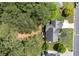 Aerial view of a home with a well-manicured lawn, mature trees, and a dark roof at 220 Galesburg Dr, Lawrenceville, GA 30044