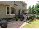 Back exterior view of the home with deck, patio, and landscaped yard at 220 Galesburg Dr, Lawrenceville, GA 30044